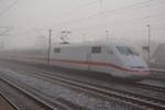 Durch dicken Nebel kommt dieser ICE 1 aus Hamburg und fährt soeben durch den Bahnhof Falkensee. Aufgenommen am 04.12.2016.