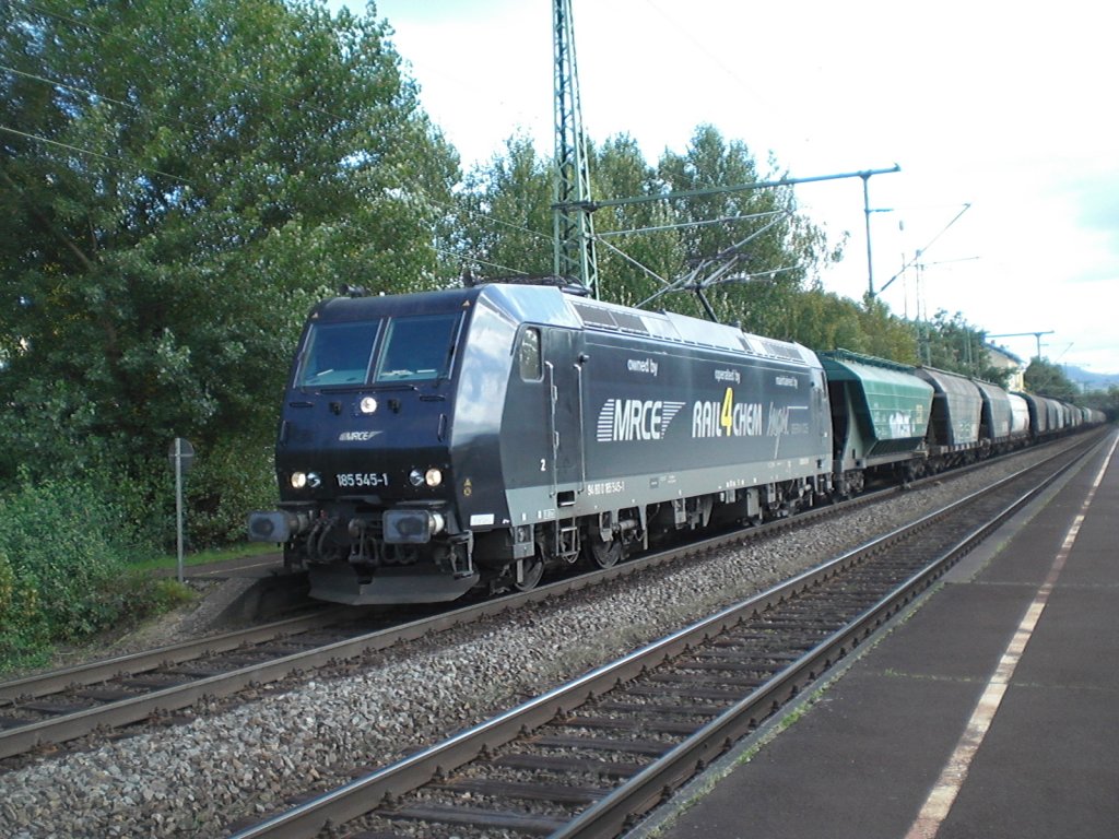 Br.185 545-1 von (R4C) Rail4Chem mit der Rail4Chem,MGW Service und MRCE Werbung auf der Seite und vor einem Getreidezug.