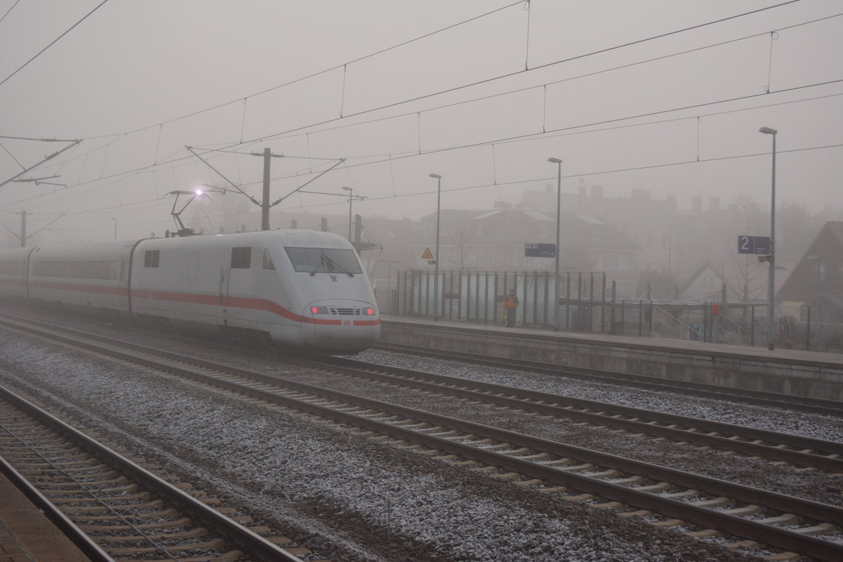 Durch dicken Nebel kommt dieser ICE 1 aus Hamburg und fährt soeben durch den Bahnhof Falkensee. Aufgenommen am 04.12.2016.